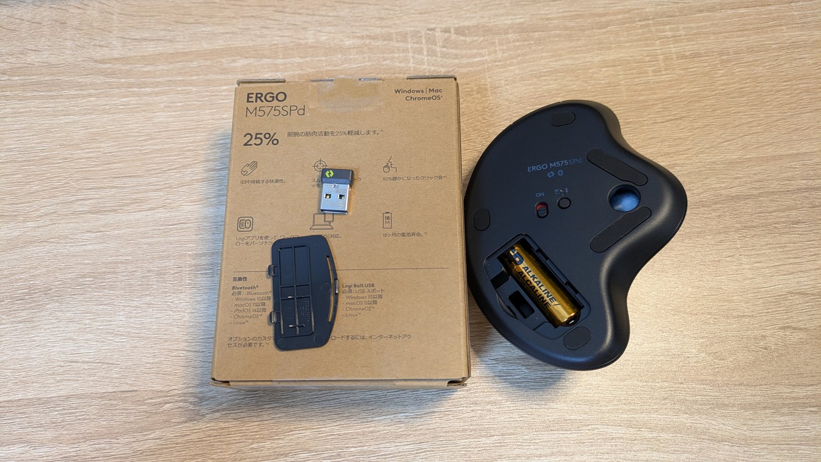 ERGO M575SPd の裏面、単3電池が入った電池室と電源スイッチ、横に Logi Bolt の USB レシーバーと電池ぶた